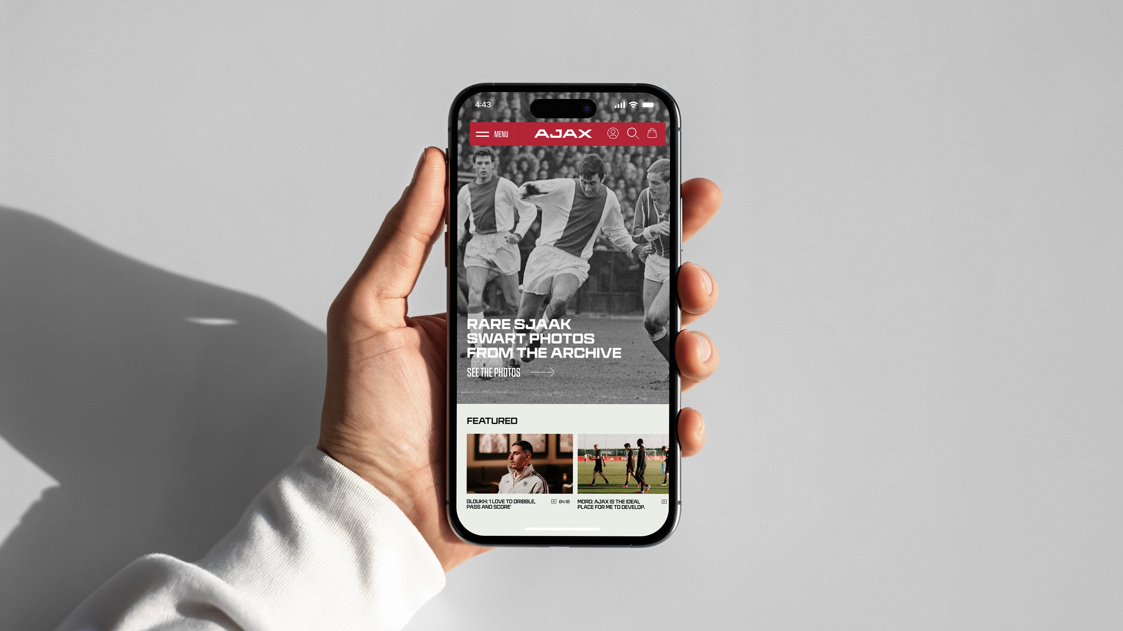 AFC-Ajax-_0032 Rare Sjaak archival sports photographs displayed on a smartphone screen held by a person's hand.