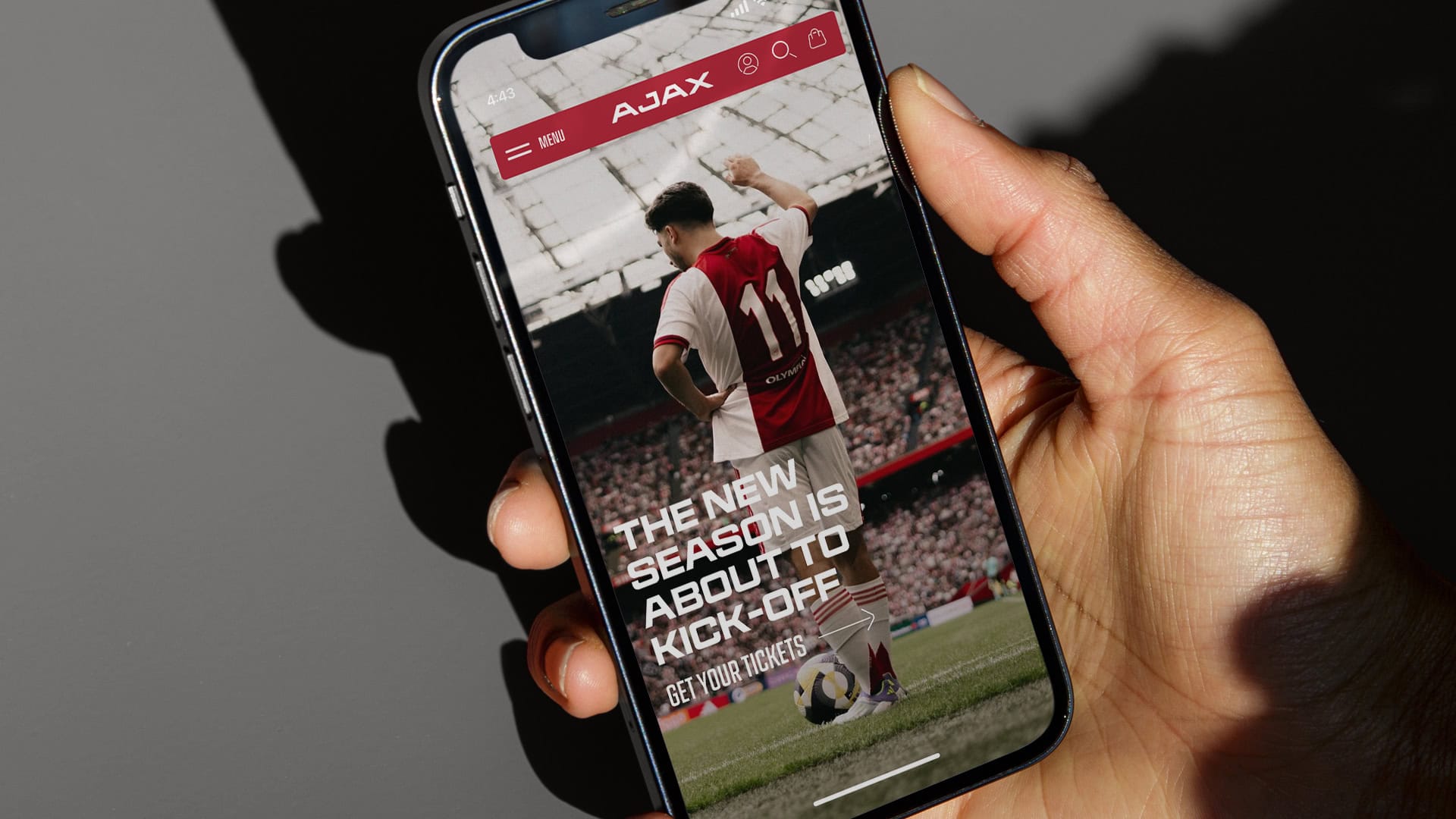 AFC-Ajax-_0033 A soccer fan holding a smartphone displaying a sports event promotion for upcoming kick-off season tickets.