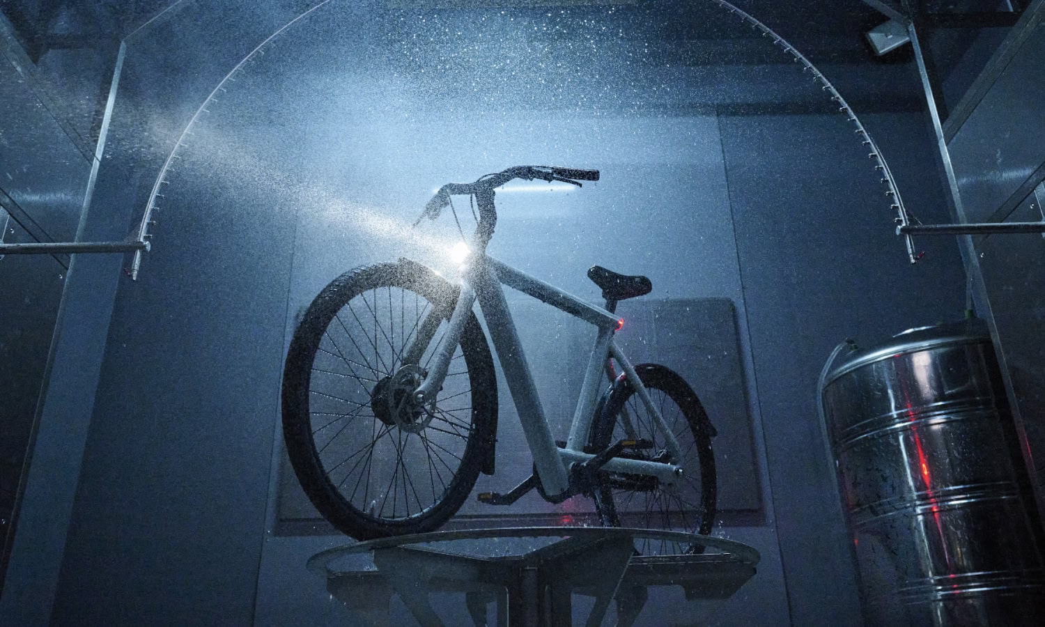 Bike Display at Vincent Venema Exhibition A bicycle showcased in a modern, illuminated display with water spray effects, highlighting innovative design and craftsmanship.